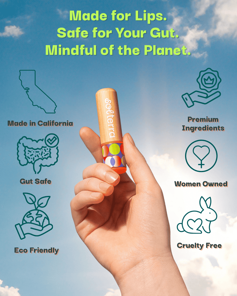 Hand holding a lip balm with branding and sustainability claims against a blue sky background